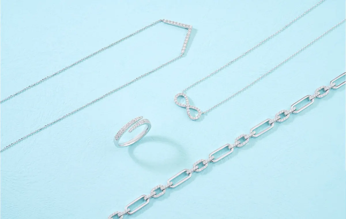 Assortiment de bijoux fantaisie colorés posés sur tissu blanc