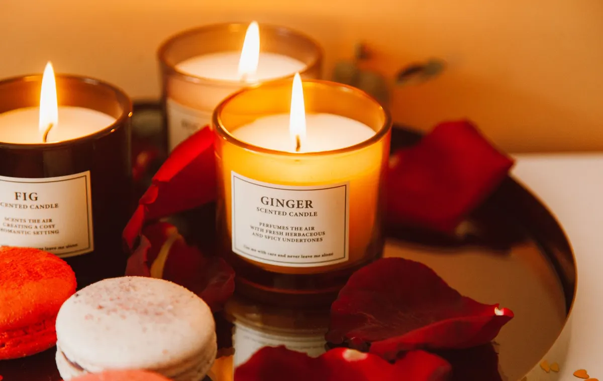 Bougie parfumée allumée posée sur un plateau en marbre dans un salon chaleureux