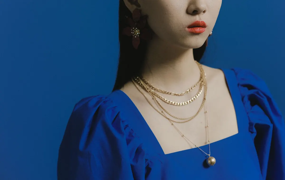 Collier femme en or jaune porté sur une tenue sobre