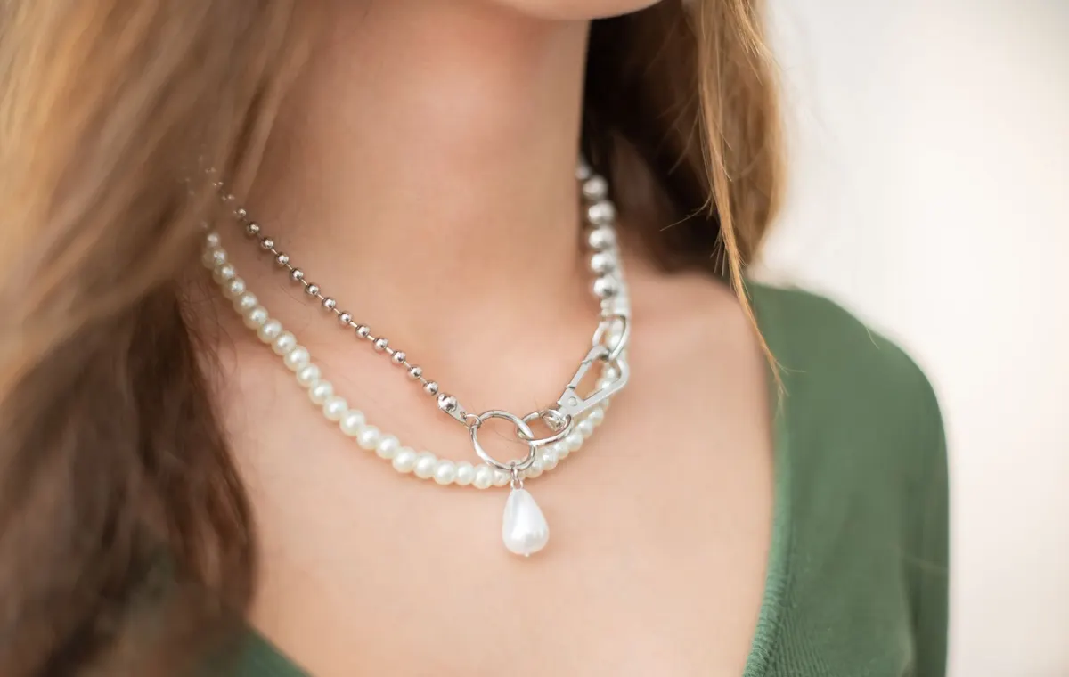 Plusieurs colliers femme posés sur marbre blanc