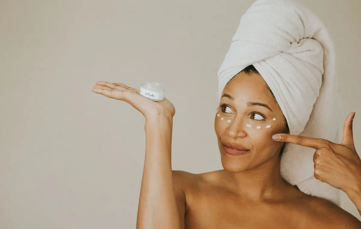 Application de crème contour des yeux du bout des doigts