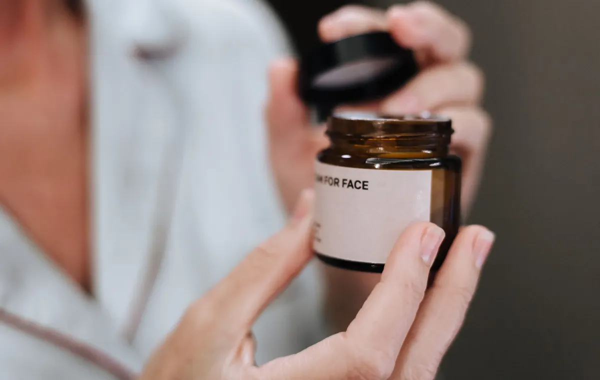 Pot de crème visage de luxe sur fond blanc avec fleurs
