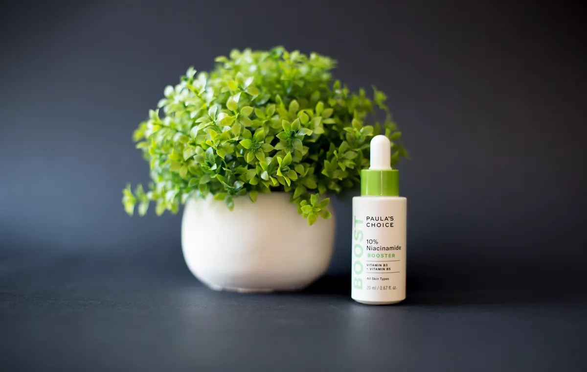Flacon de sérum au niacinamide sur fond beige épuré