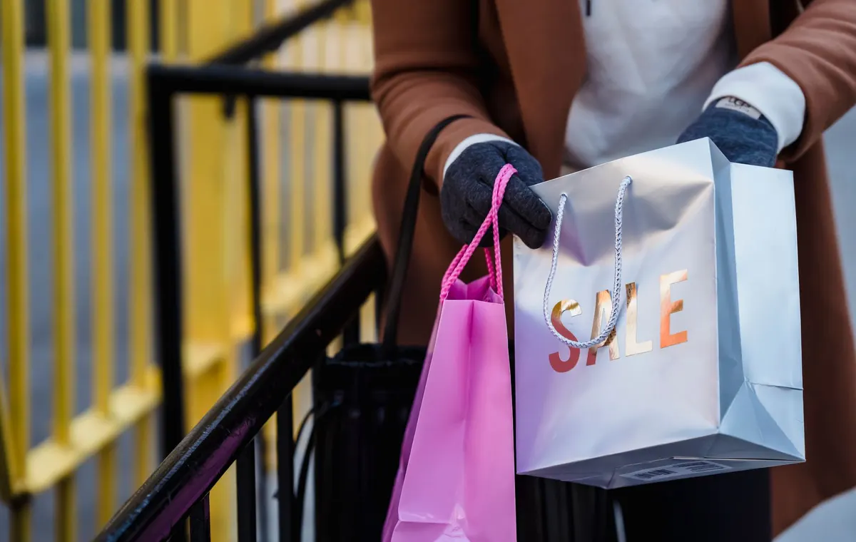 Femme élégante avec des sacs de shopping lors des soldes
