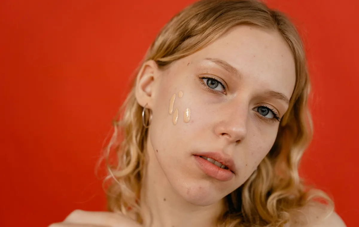 Maquillage teint naturel avec pinceau fond de teint sur fond beige